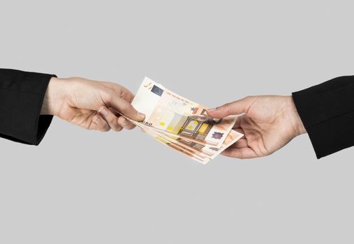Concept image of hands making and receiving a payment, isolated over a gray background
