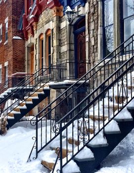 Snow covering the entrances to colorful townhouses in Montreal, Canada.