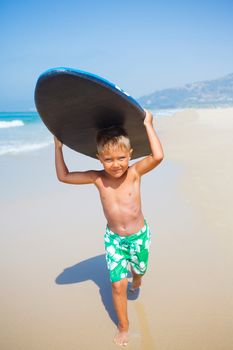 Boy has fun on the surfboard in transparency sea