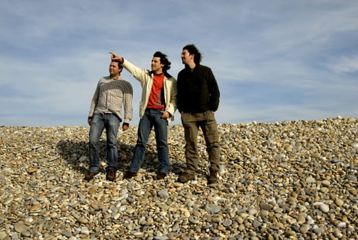 three young casual men at the beach