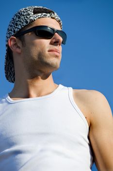 young casual man looking with the sky as background