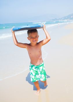 Boy has fun on the surfboard in transparency sea