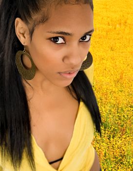 young beautiful woman closeup portrait among yellow flowers