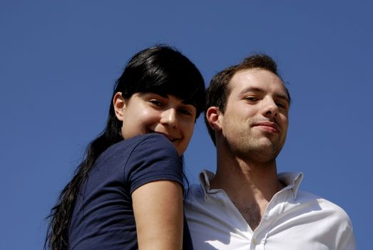 young couple with the sky as background