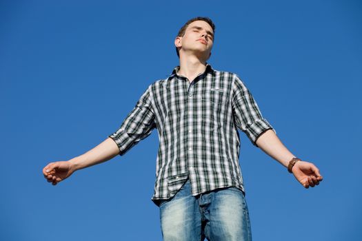 young casual man with the sky as background