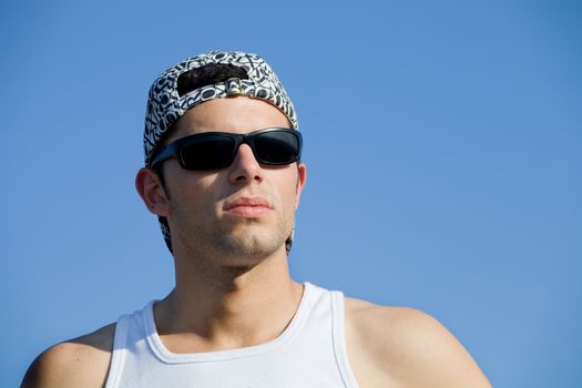 young casual man looking with the sky as background