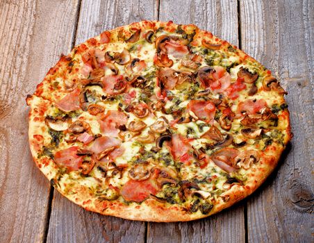 Freshly Baked Pizza with Edible Mushrooms, Bacon, Cheese and Spinach Sauce isolated on Rustic Wooden background