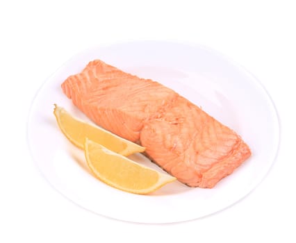 Fried salmon fillet on plate with lemon. Isolated on a white background.