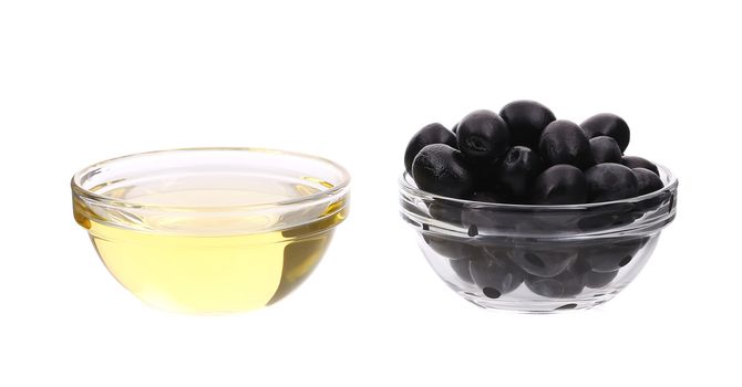 Sunflower oil and olives in glass bowl. Isolated on a white background.