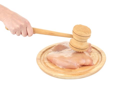 Raw chicken breast and mallet on wooden board. Isolated on a white background.