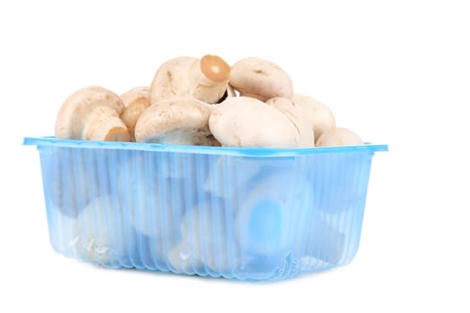 Champignon mushrooms in a blue box. Isolated on a white background.