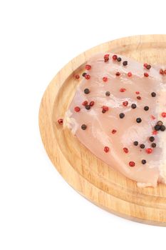 Raw chicken breast pepper on wooden board. Whole background.