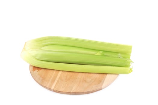 Fresh green celery on wooden platter. Isolated on a white background.
