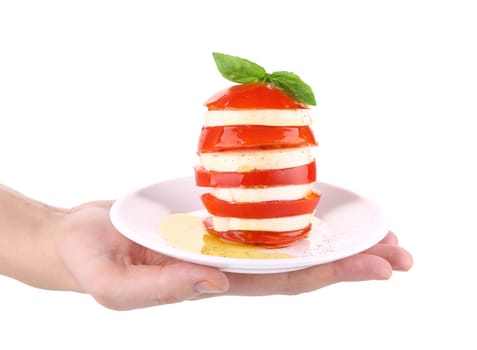 Caprese salad on plate in hand. Isolated on a white background.