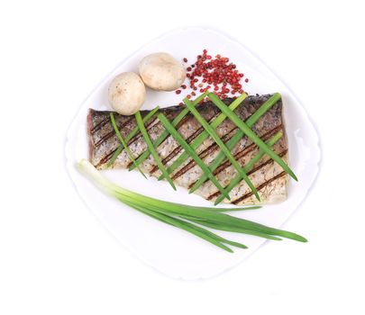 Grilled fish with green onions and peppercorn. Isolated on a white background.