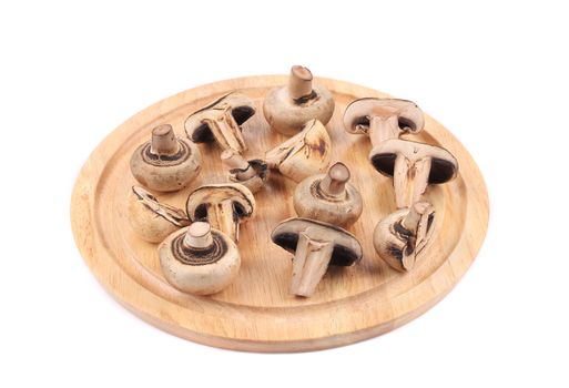 Sliced mushrooms on wooden platter. Isolated on a white background.