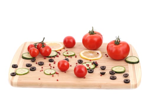 Vegetables and olives on cutting board. Isolated on a white background.