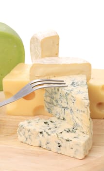 Various types of cheeses on wood. On a white background.