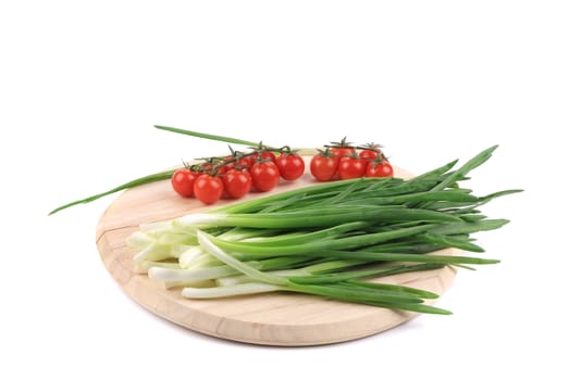 Onions and cherry tomatoes on a wooden board. Isolated on a white background.
