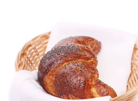 Image of croissant with poppy in a basket. Whole background
