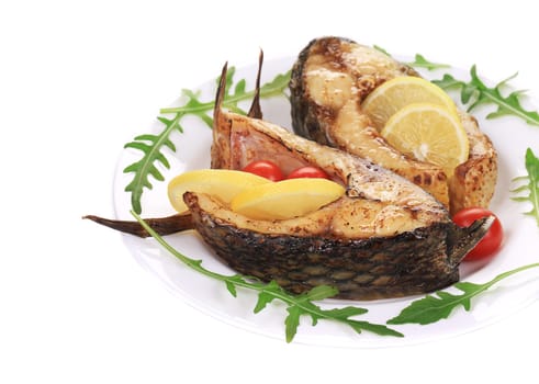 Grilled carp steaks with lemon and tomatoes. Whole background.
