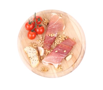 Composition of prosciutto on wooden platter. Isolated on a white background.