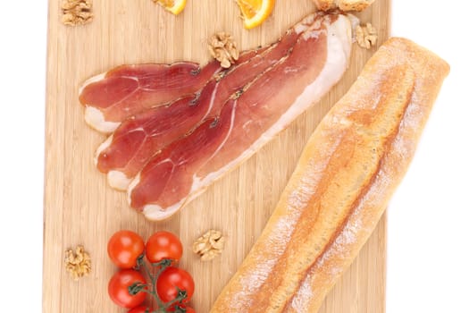 Prosciutto with cherry tomatoes and walnuts. Whole background.