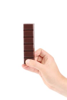 Hand holds piece of chocolate bar. Isolated on a white background.