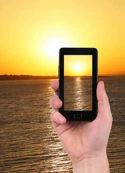Taking sunset photo on smartphone. Isolated on a white background.
