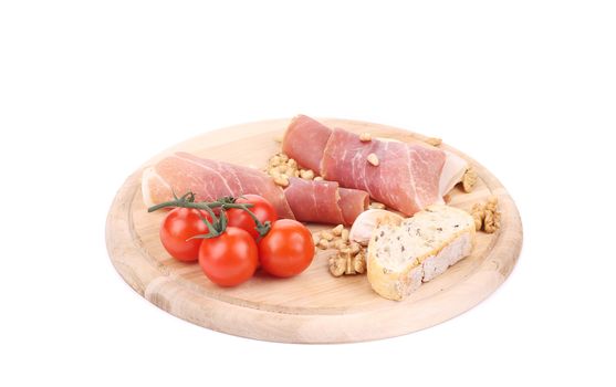 Prosciutto and tomatoes with bread on platter. Isolated on a white background.