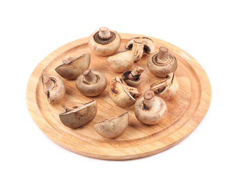 Mushrooms on wooden platter. Isolated on a white background.