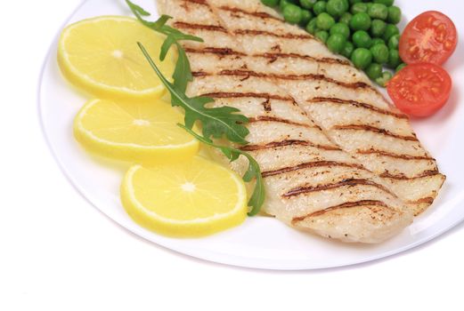 Grilled fish fillet with vegetables. Isolated on a white background.