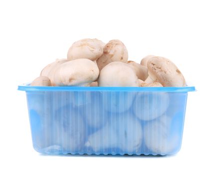 Champignon mushrooms on plastic box. Isolated on a white background.