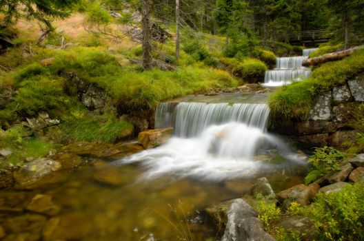 Amazing cascade in a wooded mountainous landscape 