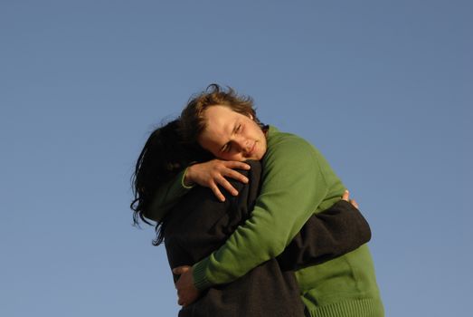 young couple with the sky as background