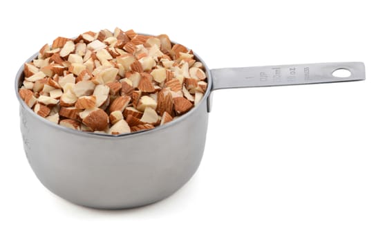 Chopped almonds presented in an American metal cup measure, isolated on a white background