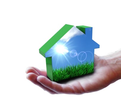 Nature and renewable energy concept with a man hand holding a green house icon with grass, blue sky and sun rays. Isolated on white background.