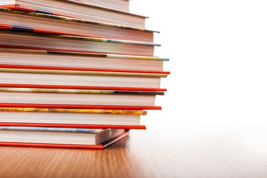 Pile of different books put on a wooden table