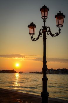 Sunset Over The City Of Venice, Italy With Streetlamps In The Foreground