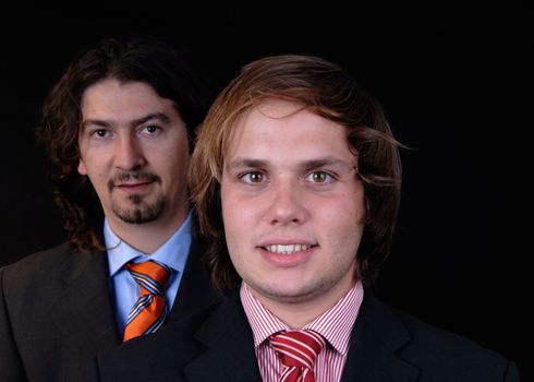 business man portrait isolated on black background, focus on the right man