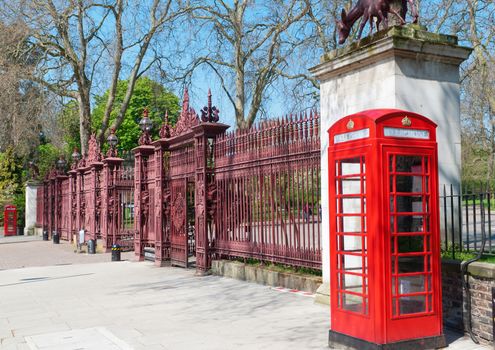 Two typical London bright red phone cabins infront big door