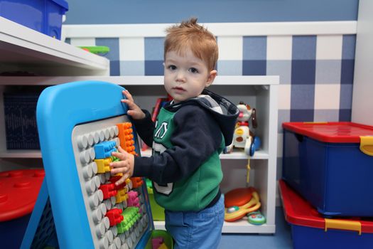 A baby boy playing with plastic blocks