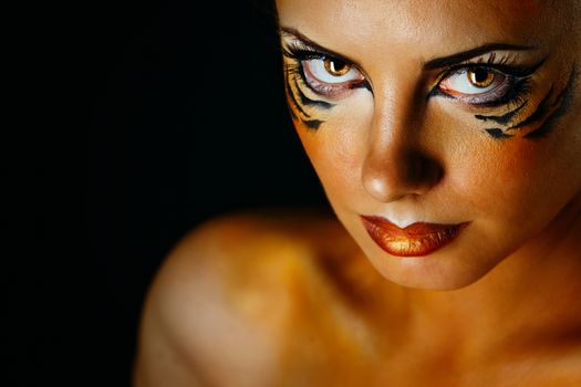 Beautiful and dangerous girl tigress with predatory gaze close-up portrait