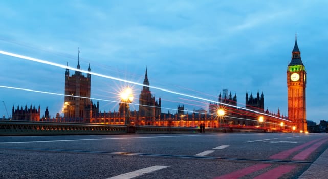 Big Ben, one of the most prominent symbols of both London and England, as shown at night along with the lights of the cars passing by