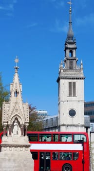 catholic monument and red bus in London