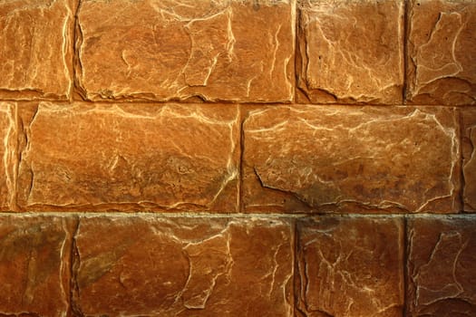 The wall of the large rectangular stones brown color with a rough surface