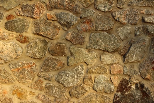High wall lined with large stones, fastened with cement