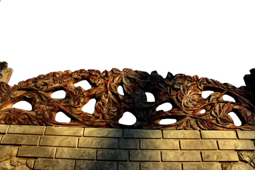 On top of the white stone fence with fine carvings in the form of branches and leaves