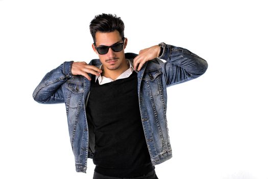 Hip, trendy young man with sunglasses and denim jacket, isolated on white