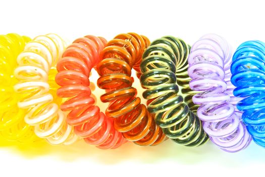 Spiral colorful elastic hair ties used on a white background.